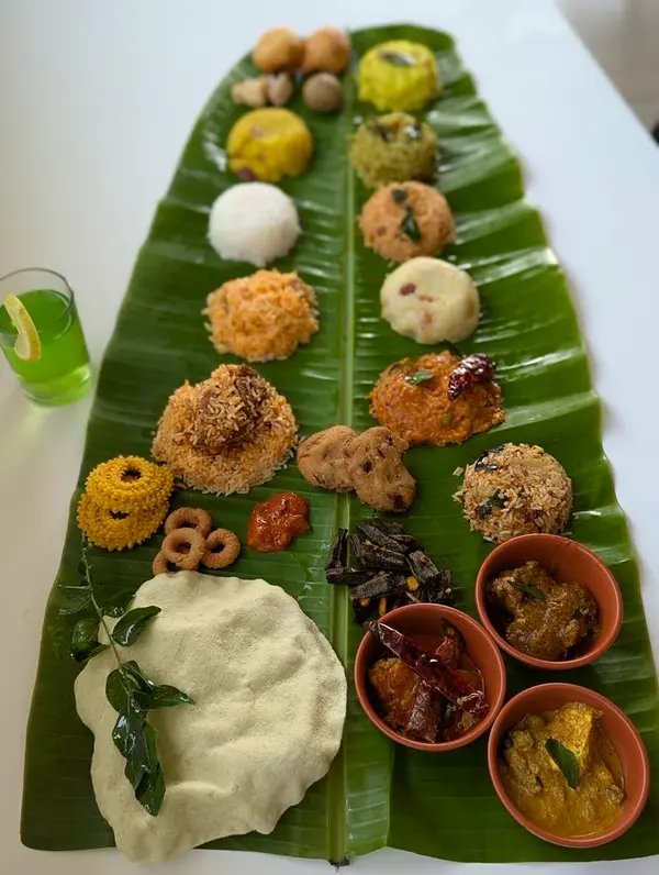 Long banana leaf laid with rice, sweets and side dishes